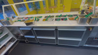 Sandwich counter with containers at a food court.
